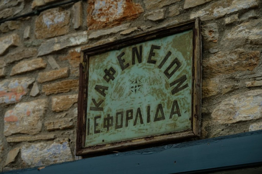 The sign of the oldest coffee shop in Greece. The Village Lafkos is one of the most beautiful and authentic places on the Greek peninsula of Pelion, characterized by an atmospheric square and the absence of cars. Vacation home in Pelion. Holidays in Greece.