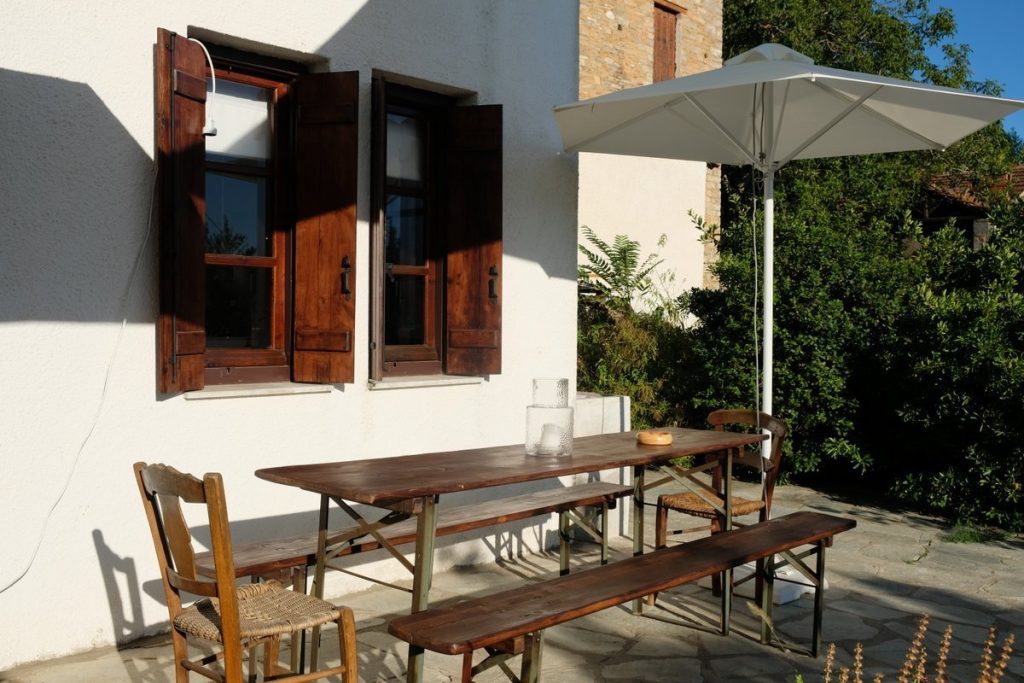Outdoor table and umbrella. Modern cottage for rent in Lafkos. House to let. Vacation home in Pelion. Holidays in Greece.